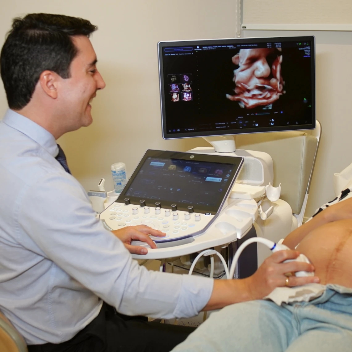 Dr. Máspoli Filho concentrado na tela do aparelho durante um exame de ultrassom