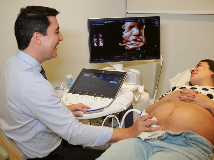 Dr. Máspoli Filho realizando um exame de ultrassom com atenção à paciente