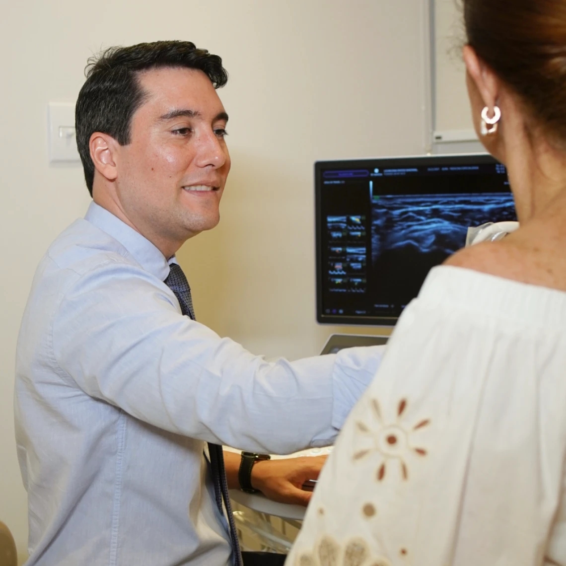 Dr. Máspoli Filho explicando o resultado do exame para a paciente no consultório