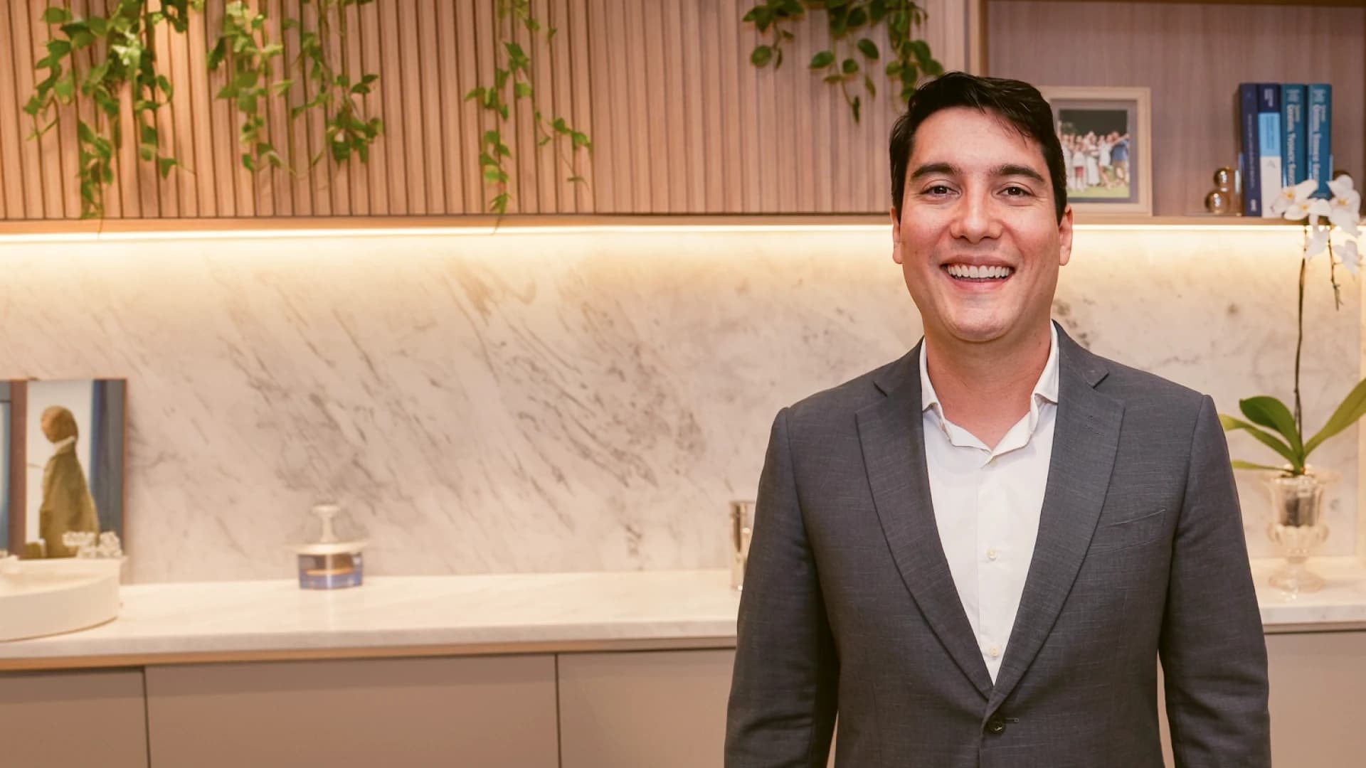 Dr. Máspoli Filho, médico ultrassonografista, sorrindo em seu consultório